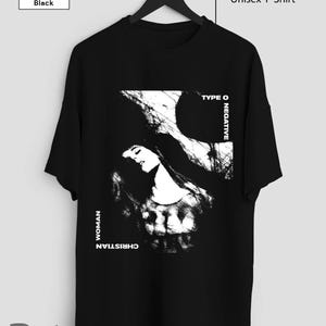 Op de afbeelding: Zwart unisex T-shirt met een witte grafische print van een vrouwen gezicht met de tekst "Type O Negative" en "Christian Woman" op de voorkant.