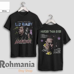 May include: Black t-shirt with a vintage-style graphic of rapper Lil Baby. The front of the shirt features a photo of Lil Baby with the text "Lil Baby" and "Harder Than Ever". The back of the shirt features a photo of Lil Baby's hand with the text "Harder Than Ever" and a list of song titles from his album.