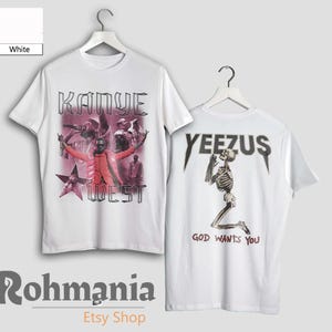 May include: White t-shirts with graphic designs. One shirt features "Kanye West" with a photo collage. The other shirt displays "YEEZUS" above a skeleton and the text "GOD WANTS YOU."