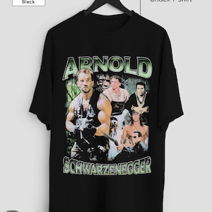 Może przedstawiać: Czarny unisexowy t-shirt z grafiką w stylu vintage przedstawiającą Arnolda Schwarzeneggera. Grafika to kolaż zdjęć Schwarzeneggera w różnych rolach, w tym "Predator" i "Terminator". Tekst "Arnold Schwarzenegger" jest nadrukowany zielonymi literami pod grafiką.