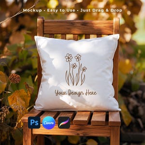 Può includere: Un cuscino quadrato bianco con un'illustrazione a linee marroni di quattro fiori con steli e foglie. Il testo "Your Design Here" è stampato in marrone sotto il motivo floreale. Il cuscino è posizionato su una sedia di legno.