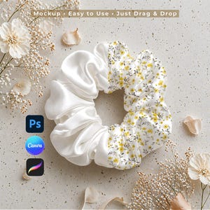 May include: A white satin scrunchie with a section of white fabric patterned with yellow flowers and green leaves. The scrunchie is on a textured surface with floral accents and the text "Mockup • Easy to Use • Just Drag & Drop".