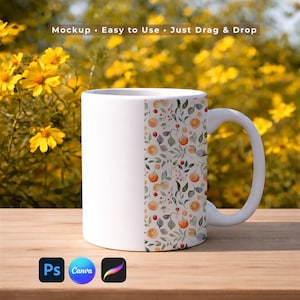 以下が含まれることがあります： 側面にはフルーツと葉の模様が入った白いセラミックマグ。デザインにはオレンジ、ベリー、緑の葉が含まれています。マグは、黄色の花のぼやけた背景のある木製の表面にあります。上部のテキストは「Mockup - Easy to Use - Just Drag & Drop」と表示されています。