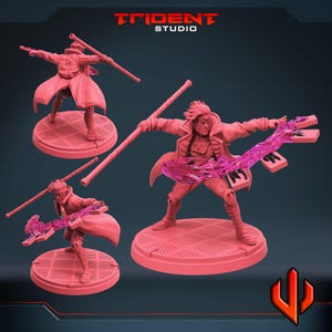 Puede incluir: Figuras de acción rosas de Gambit en varias poses, sosteniendo un bastón y efectos de energía. Las figuras están sobre bases circulares con un patrón de rejilla. El logotipo de Trident Studio está en la parte superior.