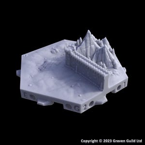 May include: A light gray miniature terrain piece featuring a mountain range, a fortress wall, and a hexagonal base. The piece has a detailed, textured surface and is likely for tabletop gaming or model building.