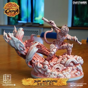 May include: A pink and white miniature figurine of Sun Wukong, the Monkey King, from Chinese mythology. The figure is posed dynamically on a cloud base, holding weapons. The base has the text "SUN WUKONG" and Chinese characters. The figurine is pre-supported.