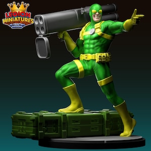 Könnte beinhalten: Eine grüne und gelbe Superheldenfigur, die eine große Waffe hält und auf einem grünen Sockel steht. Die Figur hat ein lächelndes Gesicht und trägt eine Maske. Der Sockel trägt den Text "LEGION MINIATURES 3D PRINTING DESIGNS".