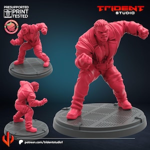 May include: A red 3D-printed figurine of a muscular character in a dynamic pose, with clenched fists. The figure is on a circular base. The image includes the text "TRIDENT STUDIO" and "PRESUPPORTED PRINT TESTED".