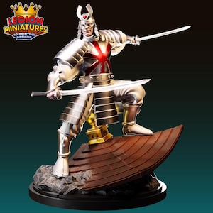 May include: A silver samurai warrior figurine with a red and white emblem on the chest, holding two swords. The figurine is posed on a brown platform, with a black base and the "Legion Miniatures" logo in the top left corner.