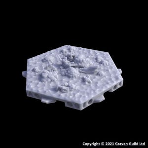 May include: A light gray, hexagonal terrain piece with a detailed, textured surface. The terrain features raised, organic shapes and what appear to be the remnants of structures. The base has several circular holes. Copyright 2021 Graven Guild Ltd.