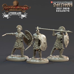 May include: Three Athenian warrior miniatures from the Greek Myth Monsters and Legends series. Each figure is clad in armor, holding a shield and either a sword or spear. The figures are on a stone-like base. The text "July 2020 Exclusive" is visible.