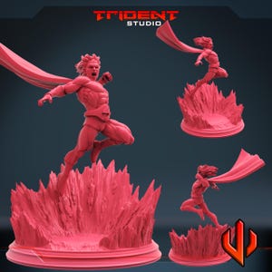 May include: A red figurine of a superhero in a dynamic pose, leaping from a textured base. The figure has a flowing cape and is set against a dark background. The Trident Studio logo is visible.