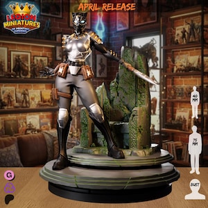 Può includere: Statuetta dettagliata di una guerriera, alta circa 7,5 cm, con un'armatura nera e argentata, che tiene una lama. La figura è su una base di pietra, con la scritta "APRIL RELEASE" in alto. È un design di stampa 3D.