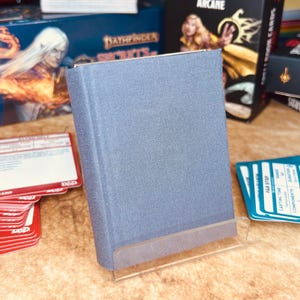 Mini livro de feitiços de capa dura com 2 inserções de pano cinza esfumaçado, 128 páginas de papel branco e um porta-cartas para D&D, Pathfinder e outros RPGs