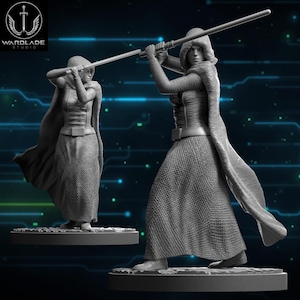 Può includere: Due figurine grigie di una figura incappucciata che brandisce un lungo bastone. Le figure sono in una posa dinamica, che suggerisce azione. Le figure indossano gonne lunghe e mantelli. Il logo "WARBLADE STUDIO" è nell'angolo in alto a sinistra.