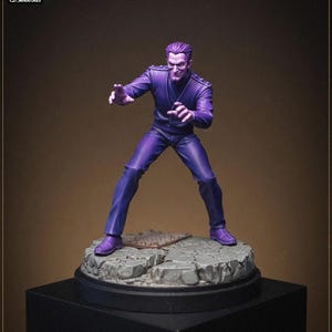 Puede incluir: Una figura en miniatura del personaje Silver Age Purple Man, representado con piel morada y vistiendo un traje morado a juego. La figura se encuentra en una pose dinámica sobre una base circular gris texturizada que simula piedra con una rejilla.
