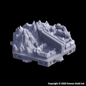 May include: A gray 3D-printed model of a mountain range with a fortress. The model features detailed peaks, trees, and a fortified structure with a wall and buildings. The base has numbered holes. Copyright 2024 Graven Guild Ltd.