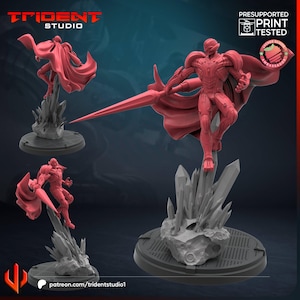 May include: A red 3D-printed figurine of a superhero with a cape and spear, standing on a rocky base. The figurine is in a dynamic pose, with the Trident Studio logo in the top left corner and "Presupported Print Tested" text in the top right.