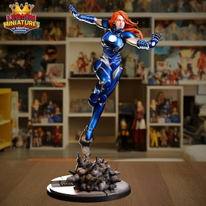 May include: A dynamic figurine of a female superhero in a blue and silver suit with red hair. The figure is posed mid-air, atop a cloud-like base. The logo "LEGION MINIATURES 3D PRINTING DESIGNS" is visible in the upper left corner.