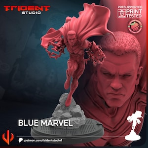 May include: A red 3D-printed figurine of Blue Marvel, a superhero, in a dynamic pose with a flowing cape. The figurine is mounted on a gray base with the text "BLUE MARVEL" and "patreon.com/tridentstudio1". The Trident Studio logo is visible.