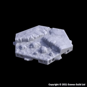 May include: A light gray, hexagonal terrain piece with detailed, textured surfaces. Features include raised cliff-like formations and several small, rounded protrusions. The base has multiple circular holes and is labeled with letters and numbers.