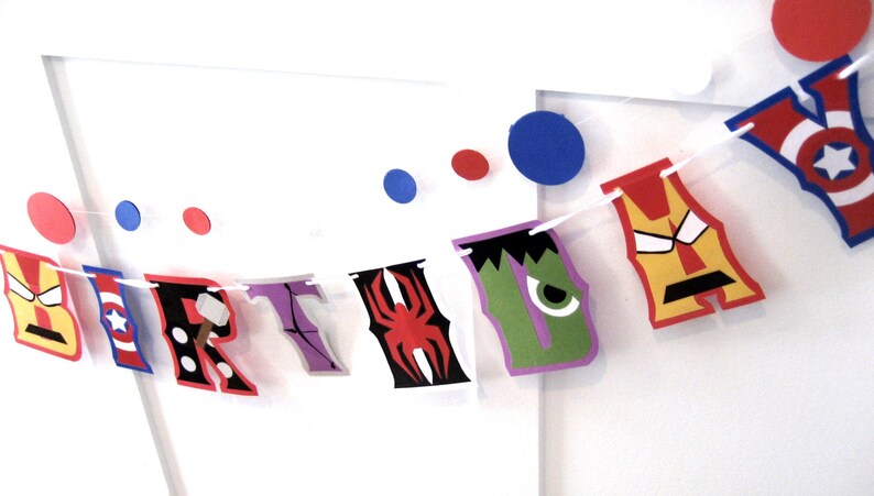 Pu&ograve; includere: Uno striscione di compleanno colorato con personaggi di supereroi. Lo striscione scrive "BIRTHDAY" con ogni lettera rappresentata da un supereroe diverso. I personaggi includono Iron Man, Capitan America, Thor, Hulk e Spiderman.