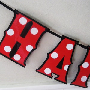 May include: Red and white polka dot banner with the word "Happy" in black letters.