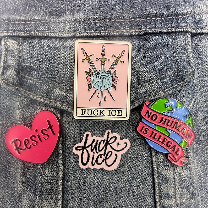 May include: Four enamel pins: a rectangular card with three swords piercing an ice cube and the text FUCK ICE, a heart-shaped pink pin with the word Resist, a pink script pin reading fuck ice, and a globe pin with a banner stating NO HUMAN IS ILLEGAL.
