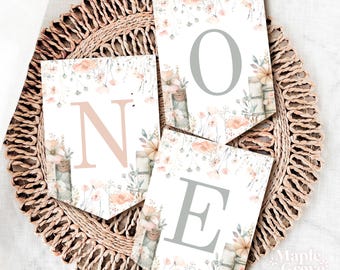 May include: A set of three pennant banners featuring floral designs and the letters "ONE" in a light grey and pink colour scheme. The banners are ideal for a first birthday party or other special occasion.