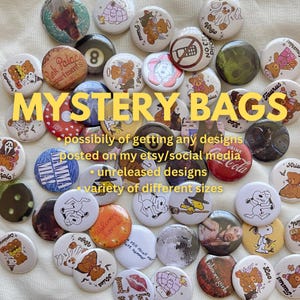 May include: A collection of colorful, round buttons with various designs, including cartoon characters, animals, and abstract patterns. The buttons are arranged on a white surface and labeled "MYSTERY BAGS". The text below the label reads "possibily of getting any designs posted on my etsy/social media • unreleased designs • variety of different sizes".