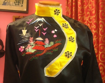 May include: A black satin shirt with a yellow and white trim. The shirt features an embroidered design of a mountain scene with a pagoda, trees, and birds.