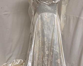Década de 1940, busto de 91 cm, cintura de 71 cm, color blanco roto, satén repujado, cola catedral, vestido de novia