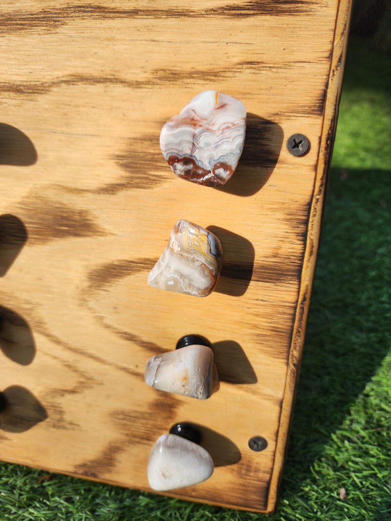 Pu&ograve; includere: Quattro pomelli in pietra di agata montati su una tavola di legno. I pomelli sono di varie tonalit&agrave; di marrone, bianco e grigio con motivi a spirale.