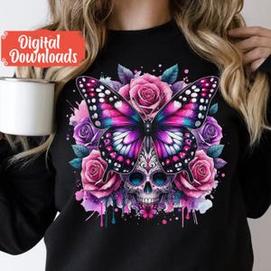Peut inclure: Un t-shirt noir avec un motif color&eacute; repr&eacute;sentant un papillon violet et rose avec une t&ecirc;te de sucre. Le papillon est entour&eacute; de fleurs roses et violettes et d'&eacute;claboussures d'aquarelle.