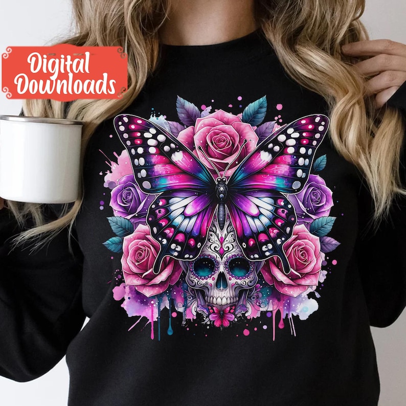Peut inclure: Un t-shirt noir avec un motif color&eacute; repr&eacute;sentant un papillon violet et rose avec une t&ecirc;te de sucre. Le papillon est entour&eacute; de fleurs roses et violettes et d'&eacute;claboussures d'aquarelle.
