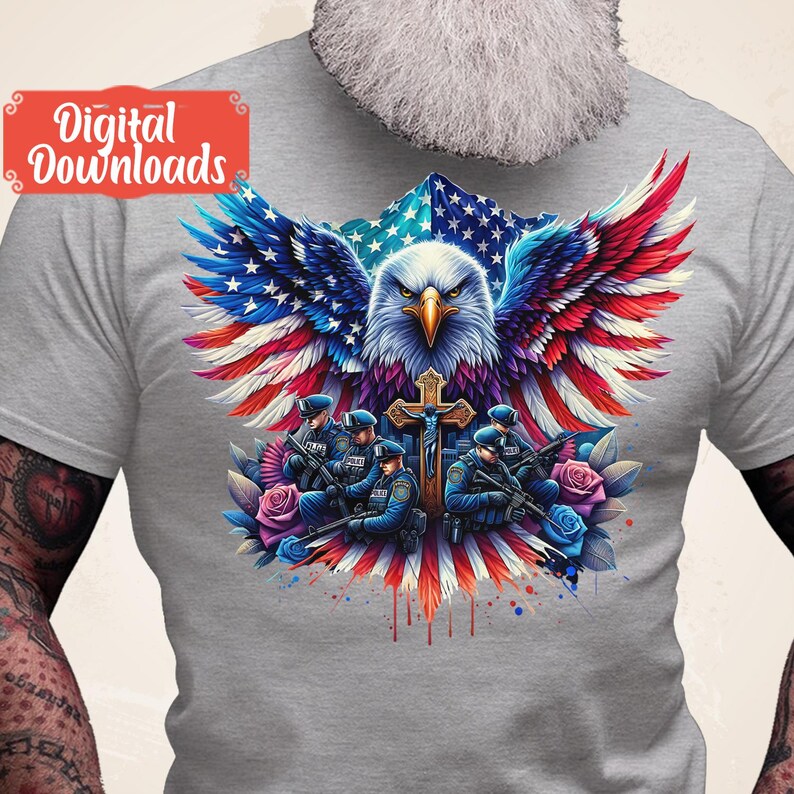 May include: A gray t-shirt with a graphic of an American bald eagle with wings spread, holding a cross. The eagle is superimposed on an American flag. Five police officers are standing in front of the eagle, holding guns. The graphic is surrounded by red, white, and blue watercolor splatters.