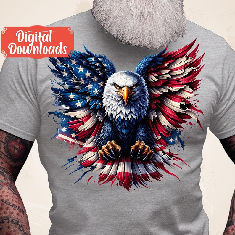 May include: A gray t-shirt with a graphic of a bald eagle with its wings spread out in the shape of the American flag. The eagle's talons are gripping the flag.