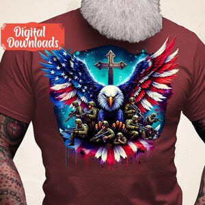 May include: A red t-shirt featuring a graphic of an eagle with American flag wings, a cross, and soldiers holding rifles. The eagle is positioned centrally in the design, with the cross above it and the soldiers surrounding it.
