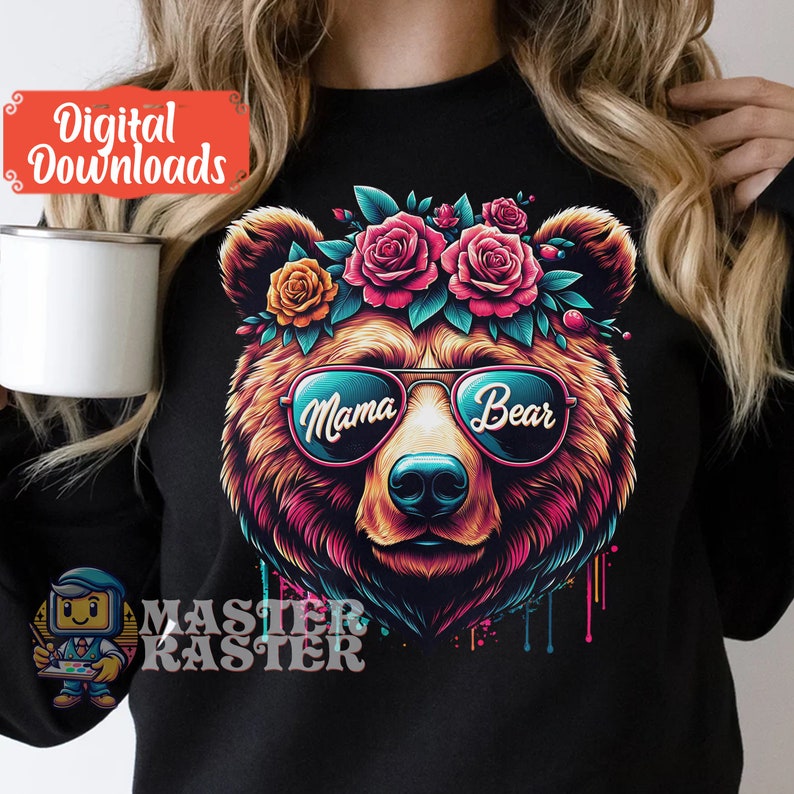 May include: A black t-shirt featuring a colourful illustration of a bear wearing sunglasses and a flower crown. The sunglasses have the words "Mama Bear" written on them.