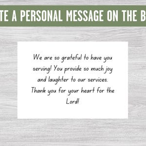 May include: A white card with a handwritten message expressing gratitude for someone's service. The message reads: "We are so grateful to have you serving! You provide so much joy and laughter to our services. Thank you for your heart for the Lord!"