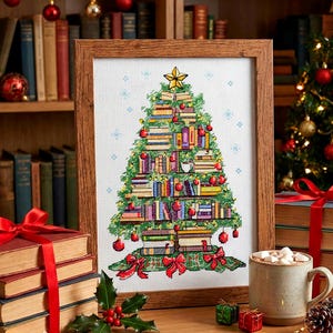Può includere: Un ricamo a punto croce incorniciato raffigurante un albero di Natale fatto di libri, adornato con ornamenti rossi e una stella d'oro. L'opera d'arte è ambientata su una superficie di legno con una pila di libri legati con un nastro rosso, una tazza di cioccolata calda e un piccolo albero di Natale sullo sfondo.