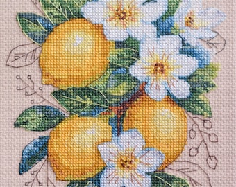 Puede incluir: Bordado de punto de cruz de limones y flores blancas con hojas verdes sobre un fondo beige.