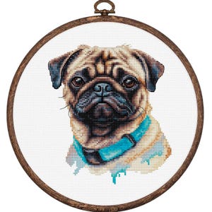 May include: Cross-stitch embroidery of a pug dog in a wooden hoop. The pug has a tan and black coat, brown eyes, and a blue collar. The embroidery is on white fabric.