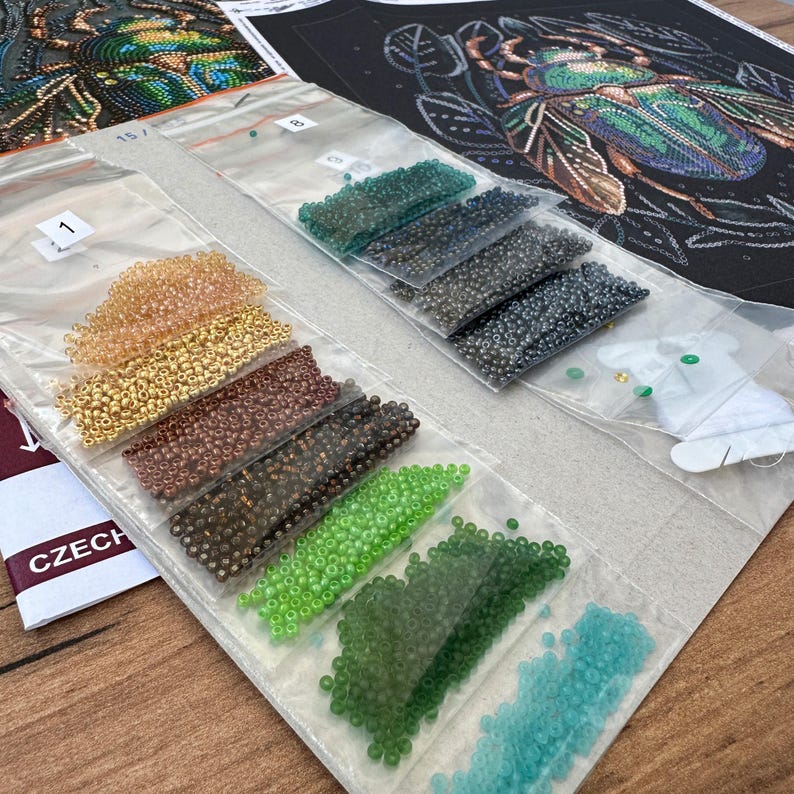 Peut inclure: Gros plan sur un ensemble de petites perles color&eacute;es dans des sachets en plastique transparent. Les perles sont dispos&eacute;es en rang&eacute;es et num&eacute;rot&eacute;es. Les perles sont destin&eacute;es &agrave; un projet de perlage.