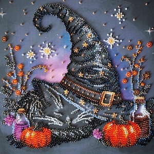 May include: A beaded Halloween-themed artwork featuring a witch's hat, pumpkins, and floral accents. The hat is black with gold stars and a brown band. Two orange pumpkins and decorative flowers are also present, all set against a dark gray background.