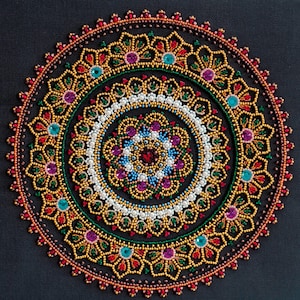 May include: A colourful beaded mandala with a circular design featuring multiple layers of beads in shades of red, gold, green, blue, and white.
