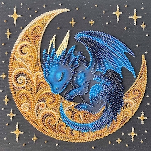 May include: A beaded artwork featuring a blue dragon curled up on a crescent moon. The moon is gold with intricate patterns, and the background is dark gray. Gold stars and dots are scattered around the moon.