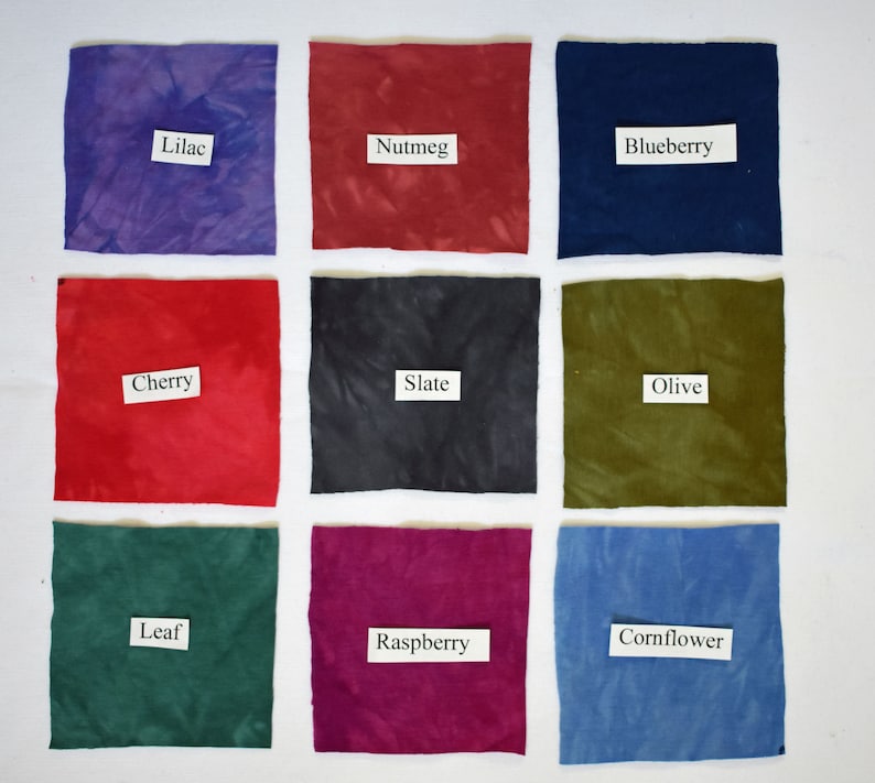 May include: Nine fabric swatches in various colors, including lilac, nutmeg, blueberry, cherry, slate, olive, leaf, raspberry, and cornflower. Each swatch has a label with the color name.