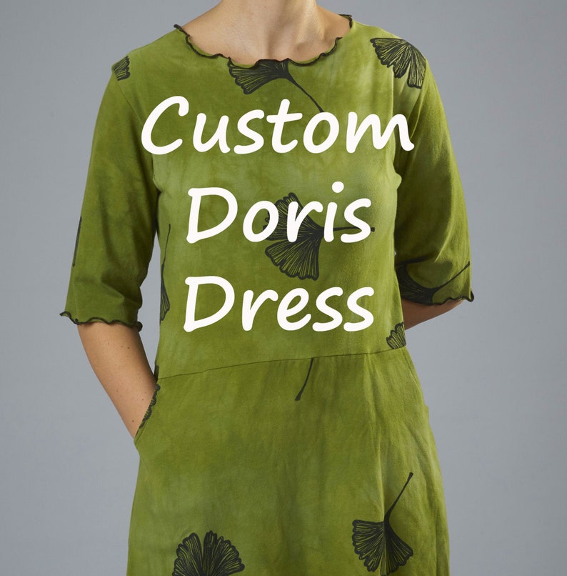 May include: A green dress with a leaf print and the text "Custom Doris Dress" printed on the front.
