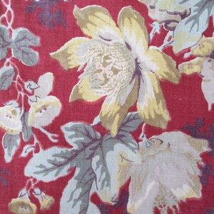 Puede incluir: Una tela roja con un patr&oacute;n floral. Las flores son blancas, amarillas y verdes. La tela tiene un aspecto vintage.